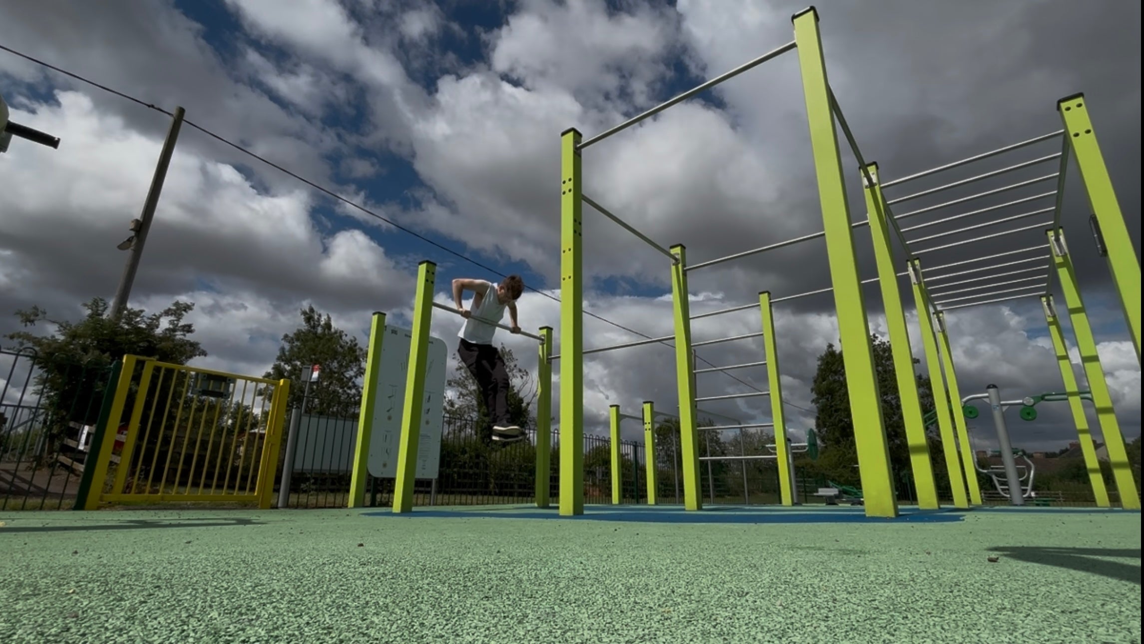 Calisthenics HQ coach doing pull-ups in a local calisthenics park in the UK — banner for our FAQs on online calisthenics lessons, coaching and courses.
